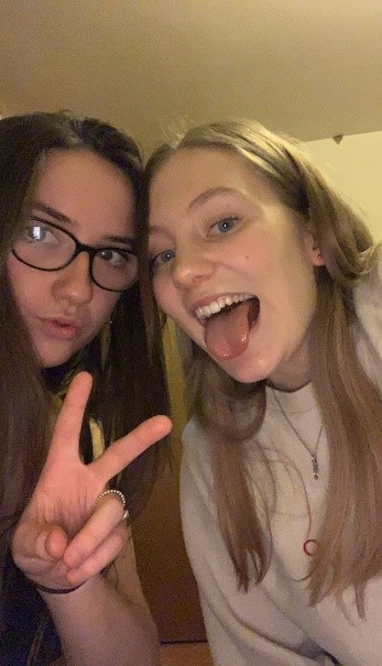 Charlotte (left) and Katie (right) taking a selfie, with Charlotte pouting and doing a peace sign, while Katie sticks her tongue out.