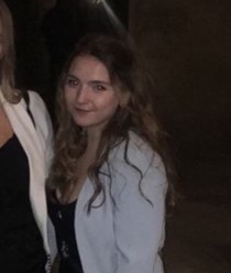 Maddie at a QCBC dinner, wearing a black dress with a white jacket.